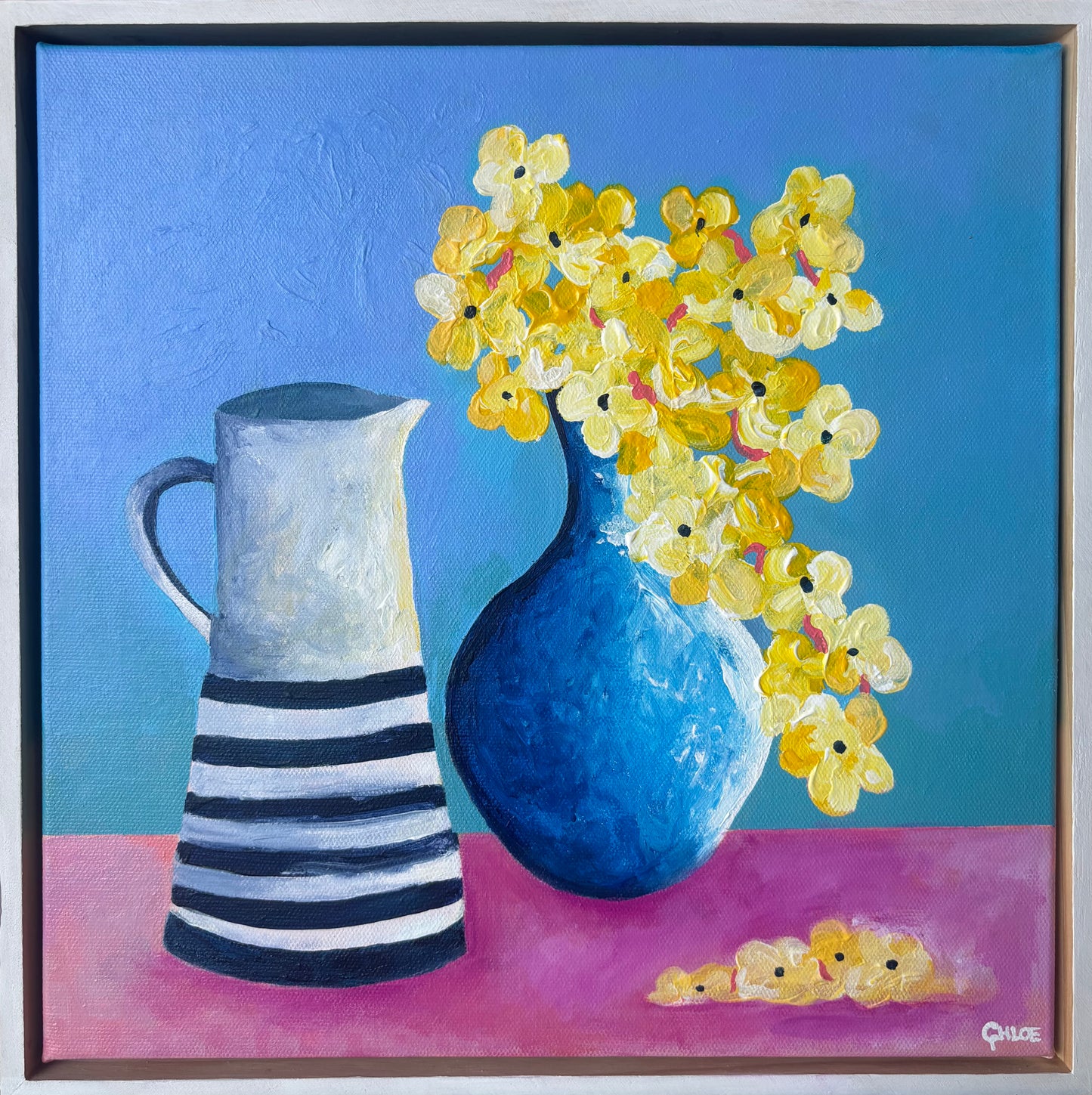 Painting of a blue vase with yellow flowers and a striped pitcher on a pink surface with a blue background.