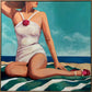 A stylized painting of a woman seated on a beach wearing a white one-piece swimsuit with a pink flower accent at the neckline and pink sandals. The background shows blue sky and ocean, with a framed artwork presentation.
