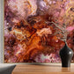 Abstract art piece with pink and orange hues on a wall above a wooden console table.