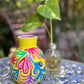 Colorful vase with floral patterns on a table outdoors
