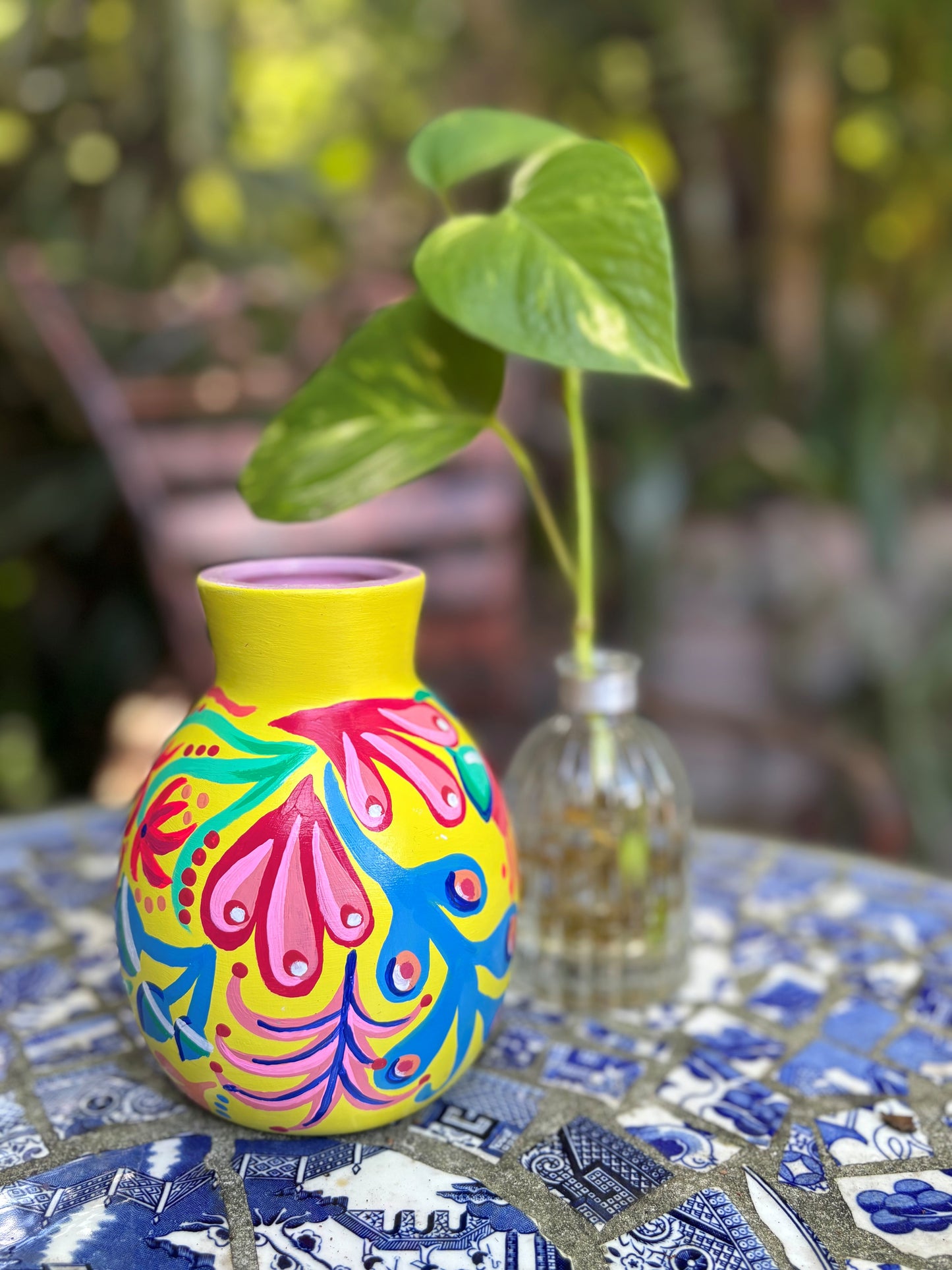 Colorful vase with floral patterns on a table outdoors