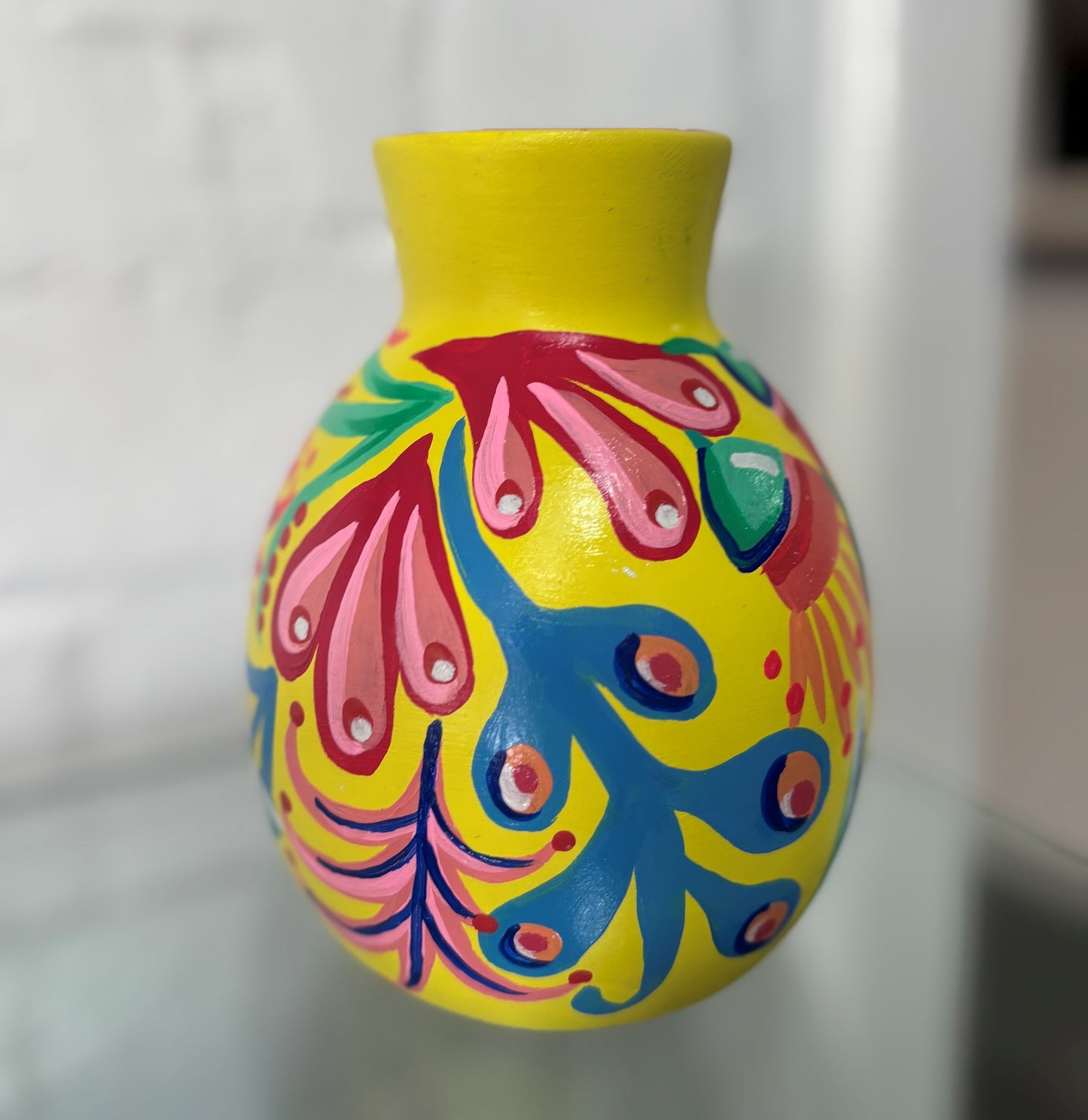Colorful hand-painted vase with abstract patterns on a white background
