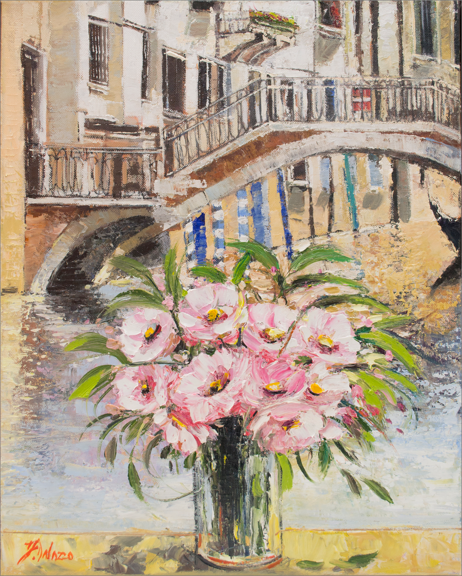 Vase of pink flowers in front of a canal with a bridge in the background