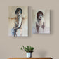 Two vertical canvas art prints depicting abstract female figures, displayed side-by-side on a beige wall above a wooden chest of drawers with a small potted plant.